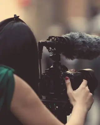 A woman filming with a video camera
